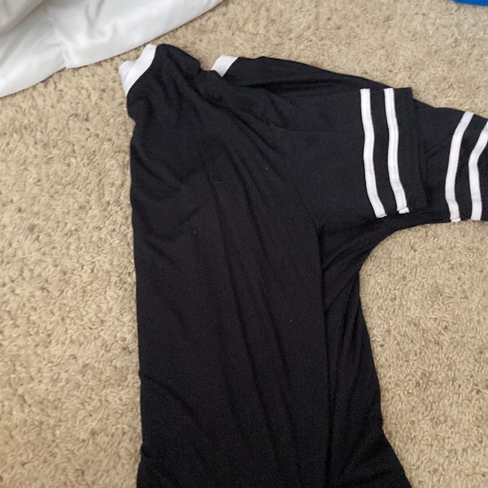 A black Tee with two white stripes on the sleeves
